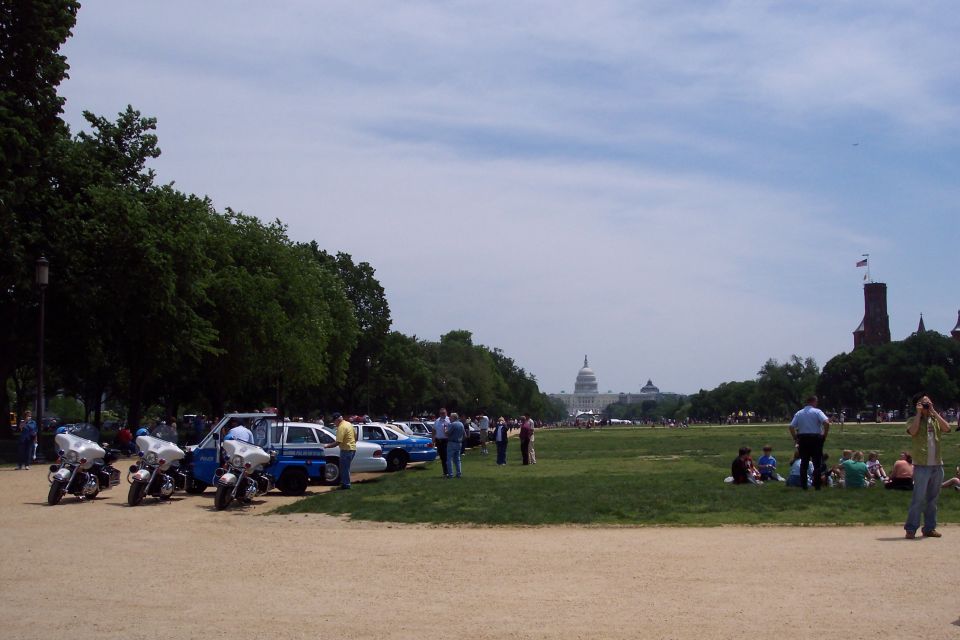 police motorcycles and cars parked on grass with Capitol building in background