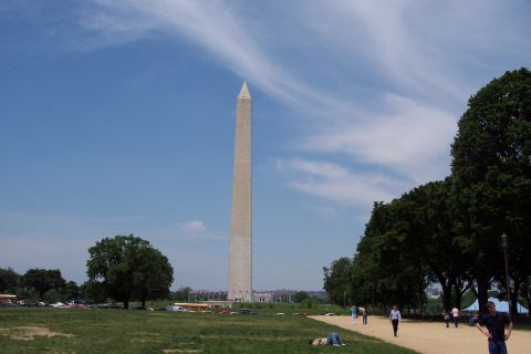 2001 Ford Crown Victoria - A wide view of the Washington Monument on a sunny day, with visitors enjoying the park grounds and vehicles in the background.