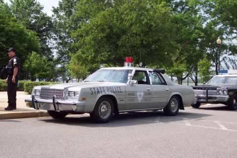 2001 Ford Crown Victoria - A 1978 Plymouth Gran Fury police car with 'STATE POLICE' markings is visible next to another vehicle.