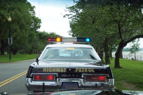 2001 Ford Crown Victoria - This Dodge Monaco police car, likely from the late 1970s, is parked near a waterfront park.
