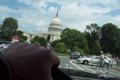 2001 Ford Crown Victoria - A view of the US Capitol Building from a car, with traffic and pedestrians present on a sunny day.