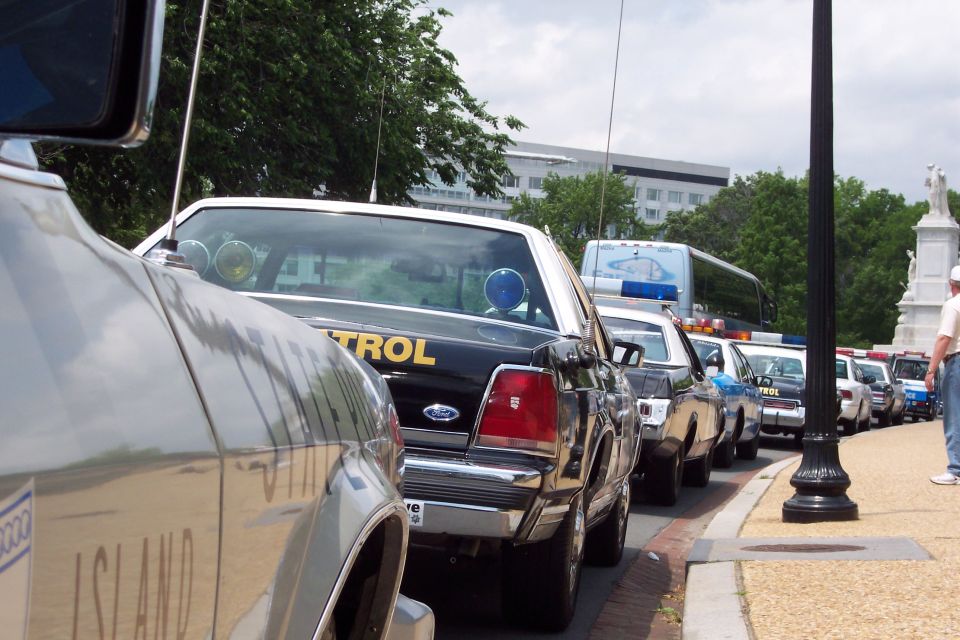 Black 2001 Ford Crown Victoria police car with yellow "CONTROL" text on rear, parked in a line