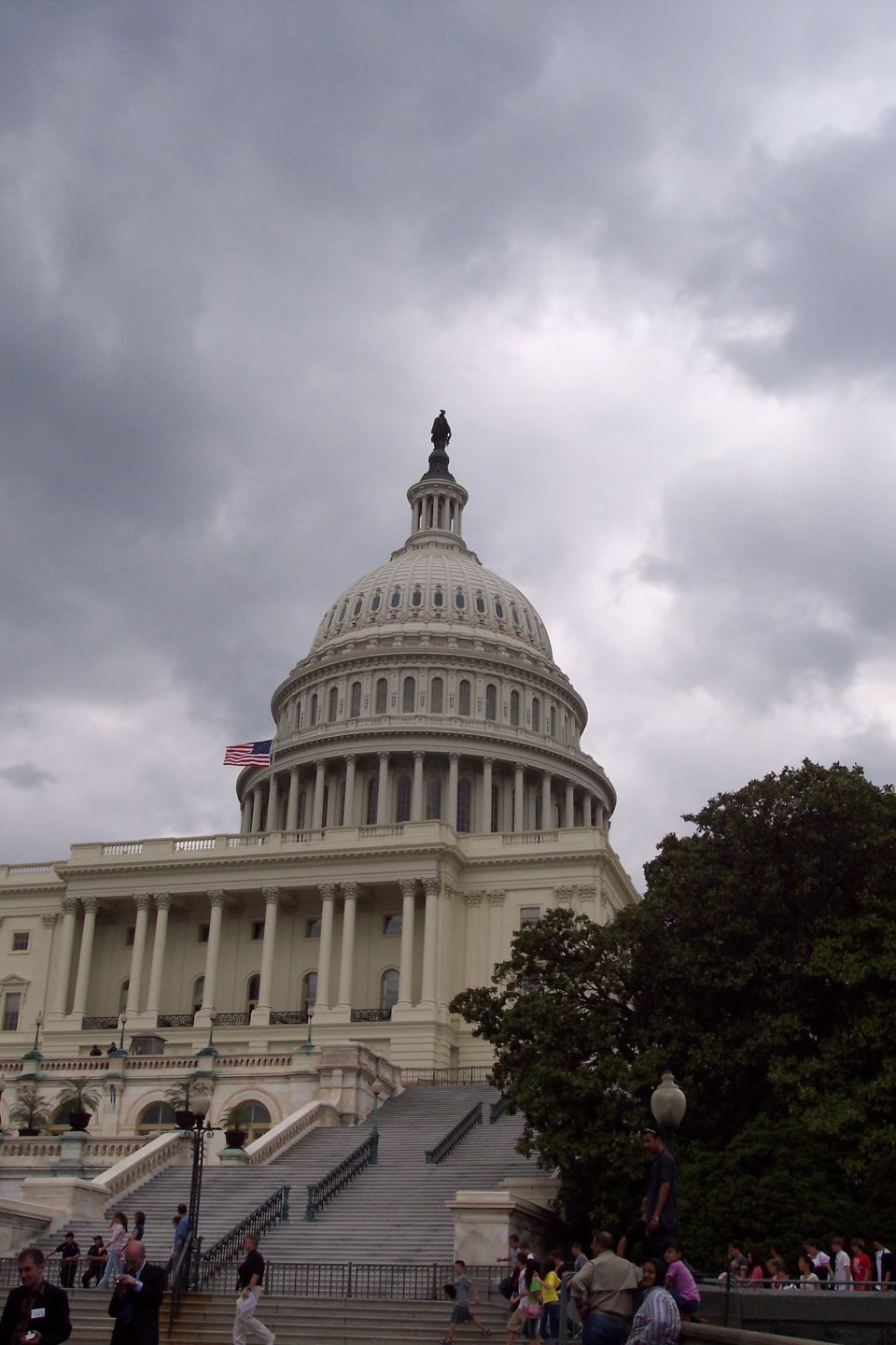 US Capitol Building with cloudy sky and people on the steps