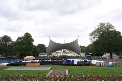 2001 Ford Crown Victoria - A large outdoor stage is set up on a grassy field, with tents and the Washington Monument visible in the background.