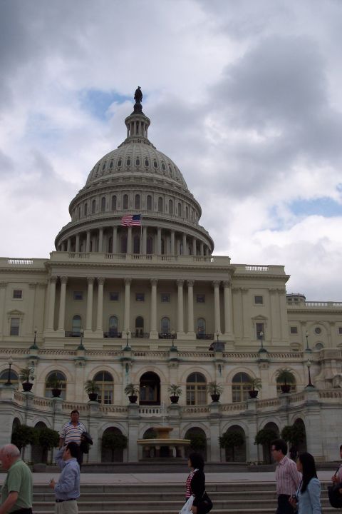 2001 Ford Crown Victoria - The US Capitol Building is seen under a cloudy sky with several people walking on the steps in front.