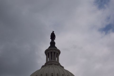 2001 Ford Crown Victoria - The Statue of Freedom stands atop the dome of the US Capitol Building under a dramatic, cloudy sky.