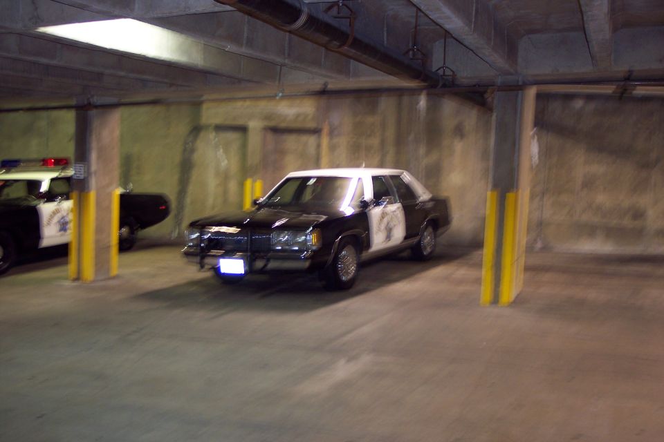Police car with push bumper parked in garage. Another police car is behind it