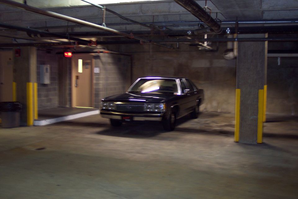 Black sedan parked in a dimly lit garage
