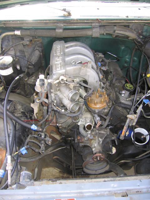 1990 Ford Bronco - Close-up view of a V8 engine, showing the intake manifold, distributor, and various hoses and wires.