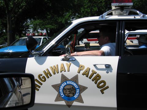 1991 Ford LTD Crown Victoria - Close-up of a black-and-white car door bearing the California Highway Patrol star and Highway Patrol lettering, with an officer seated insi…