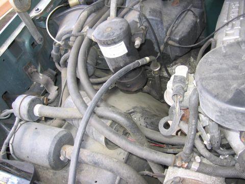 1990 Ford Bronco - Close-up view of a vehicle's engine bay, showing various mechanical parts and wiring.