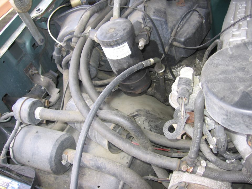 Engine bay with hoses, wires, and engine components visible
