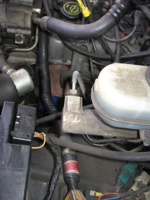 1990 Ford Bronco - Close-up of an engine bay, focusing on the brake fluid reservoir and associated components.