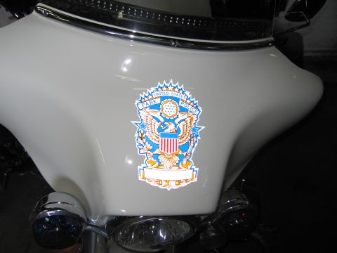 1991 Ford LTD Crown Victoria - Close-up of a United States Park Police eagle-and-shield crest decal applied to the cream fairing of a motorcycle.
