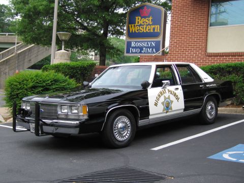 1991 Ford LTD Crown Victoria - black and white Ford LTD Crown Victoria marked Highway Patrol parked in front of a Best Western sign with a push bumper.