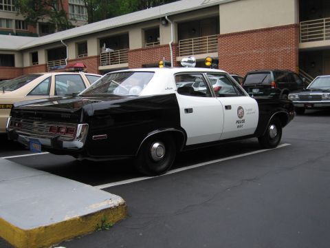 1991 Ford LTD Crown Victoria - black and white AMC police sedan marked POLICE with roof lights parked in a motel parking lot.