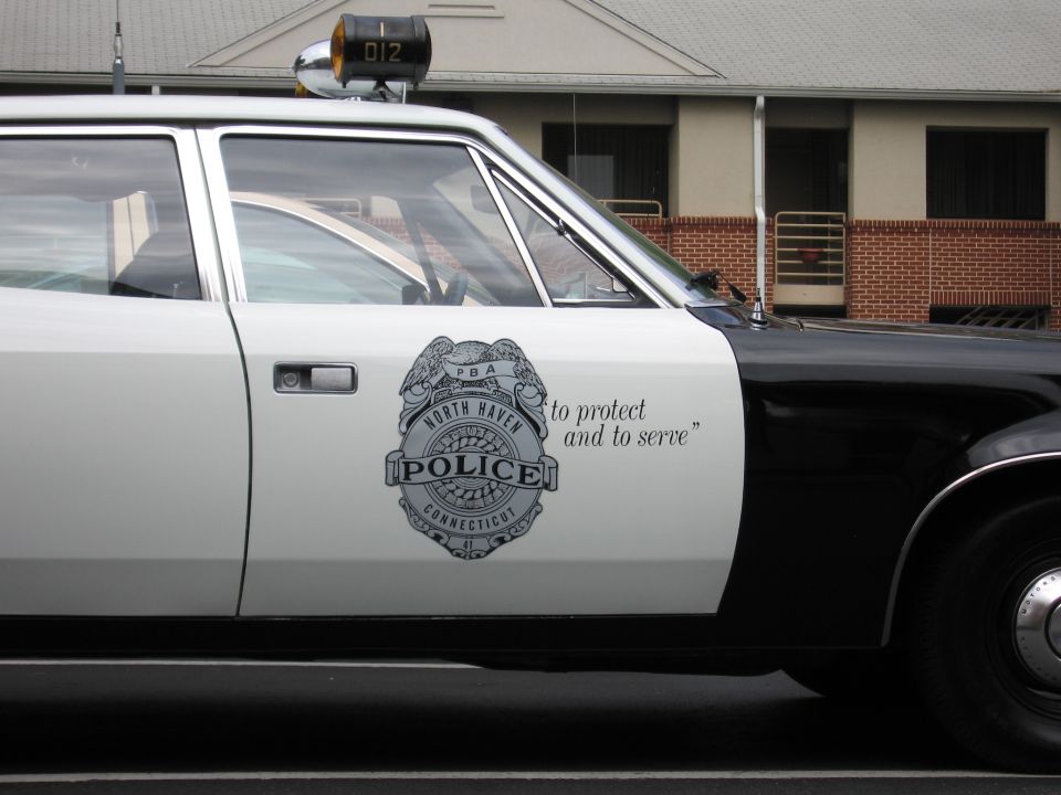 Close-up of North Haven Connecticut Police door badge with to protect and to serve motto