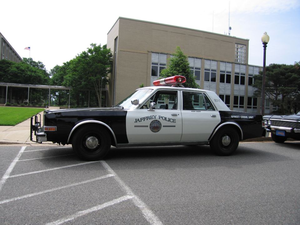Black and white Jaffrey Police sedan with push bar in parking lot