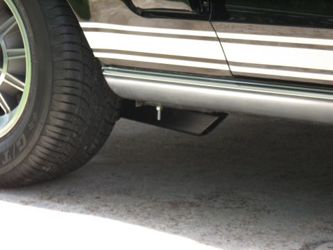 1968 Shelby GT500 - Side stripe and exhaust tip visible on a car's lower body panel.