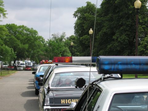 1991 Ford LTD Crown Victoria - Close view of vintage police roof lightbars in red and blue, with a black Highway Patrol cruiser in the foreground.