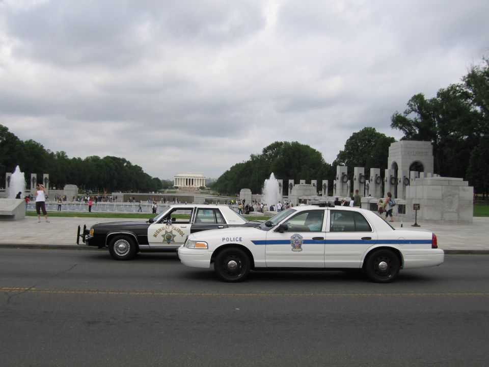 white Police Crown Victoria and a black-and-white cruiser parked near the Lincoln Memorial
