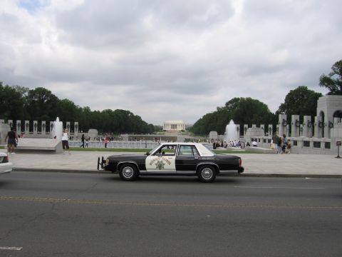 1991 Ford LTD Crown Victoria - black-and-white Highway Patrol cruiser parked across the street from the Lincoln Memorial and its fountains.