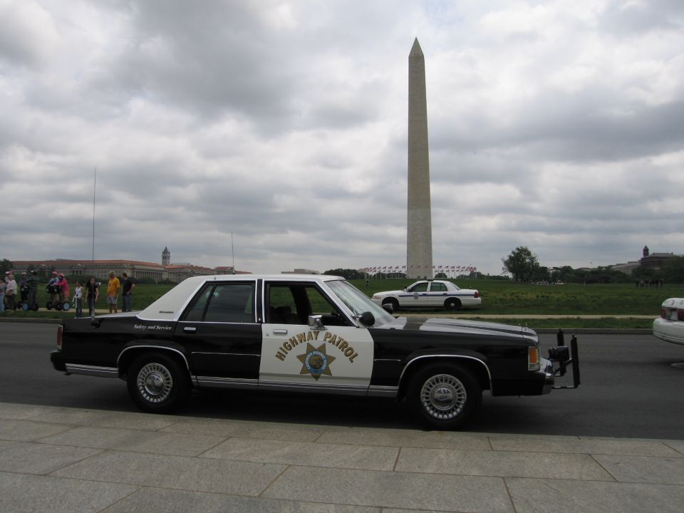 Black-and-white Highway Patrol sedan with the Washington Monument in the background