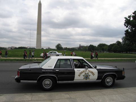1991 Ford LTD Crown Victoria - black-and-white Highway Patrol cruiser parked along the National Mall with the Washington Monument in the distance.