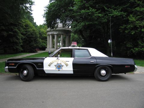 1991 Ford LTD Crown Victoria - 1970s black-and-white Highway Patrol sedan with a star door emblem is parked on a path beside a classical domed monument.