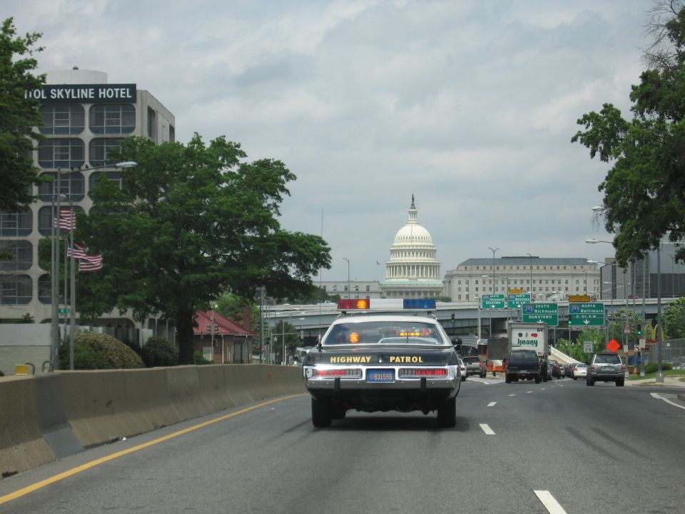 Rear of a Highway Patrol cruiser driving toward the U.S. Capitol dome