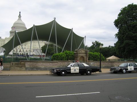 1991 Ford LTD Crown Victoria - Two black-and-white Highway Patrol sedans line the curb before a green canopy with the U.S. Capitol dome behind.