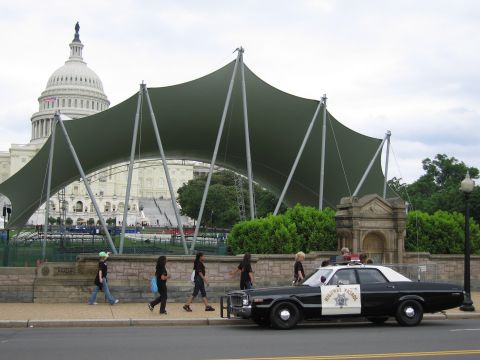 1991 Ford LTD Crown Victoria - People walk past a black-and-white Highway Patrol sedan parked before a green canopy and the U.S. Capitol.
