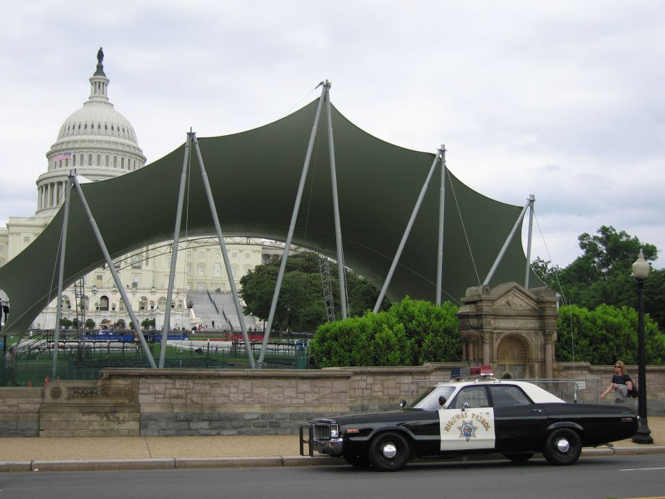 Black and white Highway Patrol sedan with green canopy and Capitol