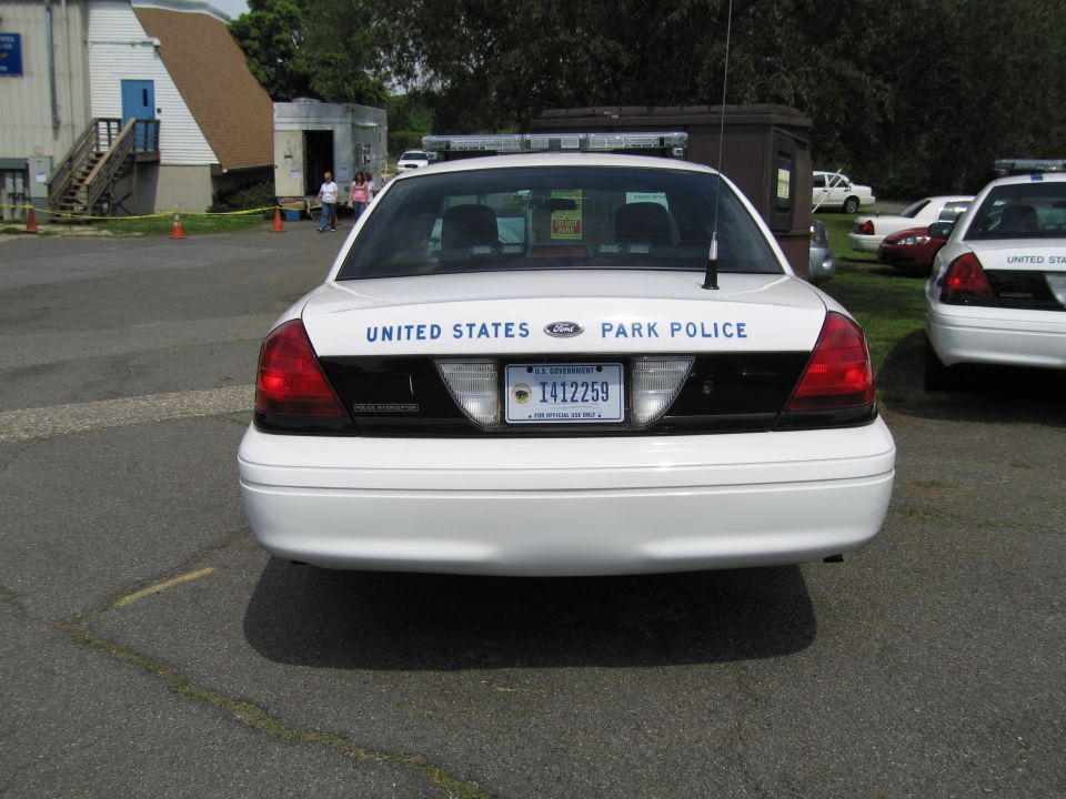Rear of white United States Park Police sedan showing trunk lettering and plate