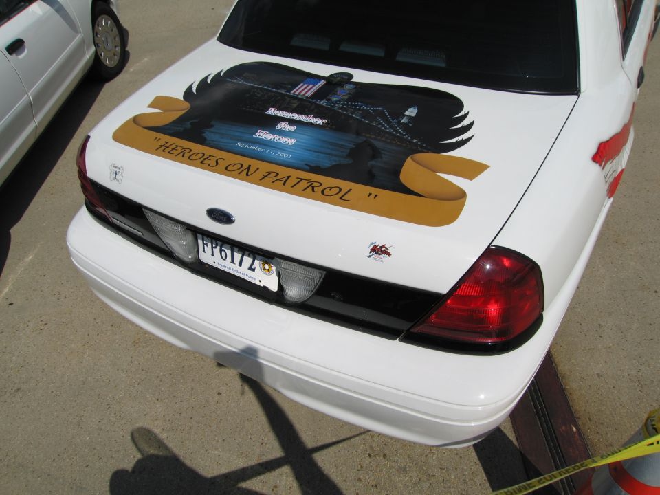 Rear of white police car with 'Heroes on Patrol' memorial trunk artwork