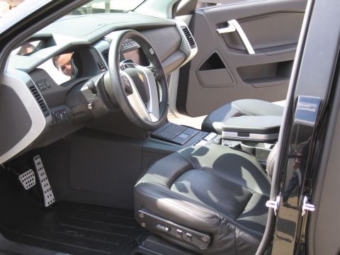 1991 Ford LTD Crown Victoria - Interior of a vehicle showing the steering wheel, a mounted laptop on the console, and black-and-camo trimmed leather seats.