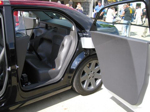 1991 Ford LTD Crown Victoria - black sedan sits with its passenger-side doors open, revealing a dark two-tone interior and alloy wheels at an outdoor show.