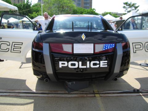 1991 Ford LTD Crown Victoria - Front view of a sleek black police concept car lettered POLICE with an LED light bar and Renault-style emblem on the hood.