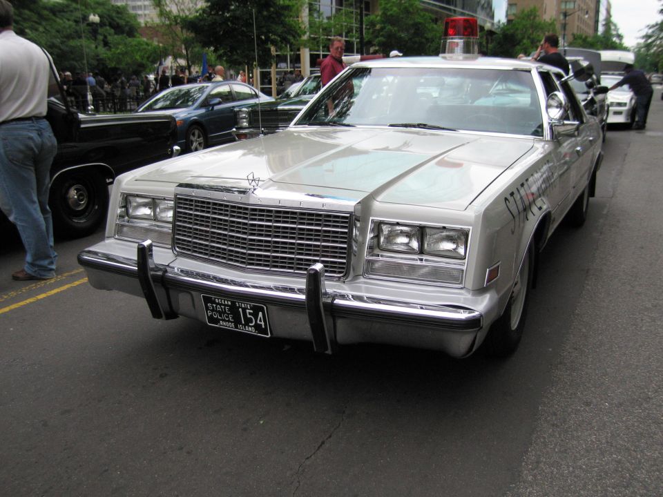 Front of a silver Chrysler sedan with roof light and Rhode Island State Police 154 plate