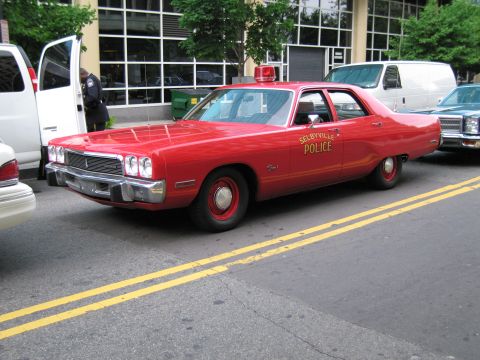 1991 Ford LTD Crown Victoria - red Selbyville Police four-door sedan with a single red roof beacon, parked along a yellow-lined street.