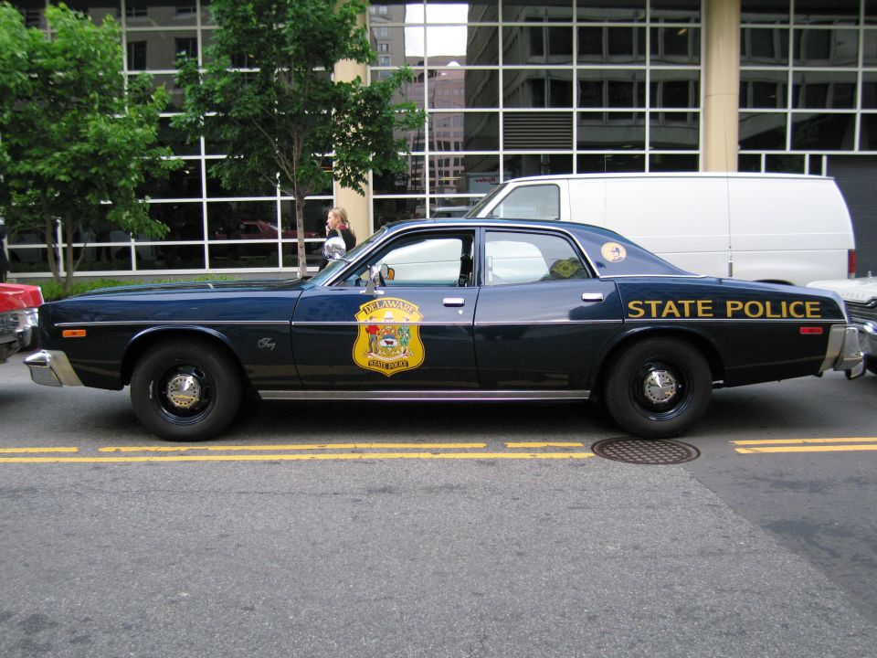 Navy State Police sedan with gold shield, driver-side profile