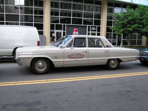 1991 Ford LTD Crown Victoria - cream-colored Monroe County Police Reserve sedan with a red roof beacon, parked in profile at a curb.