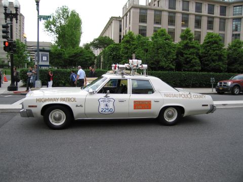 1991 Ford LTD Crown Victoria - white vintage Nassau County Police Highway Patrol sedan marked 2250 is parked along a tree-lined city street.