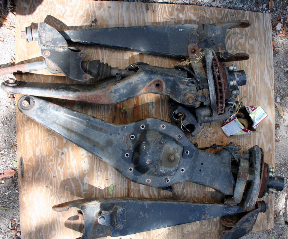 Front suspension components laid out on a wooden surface