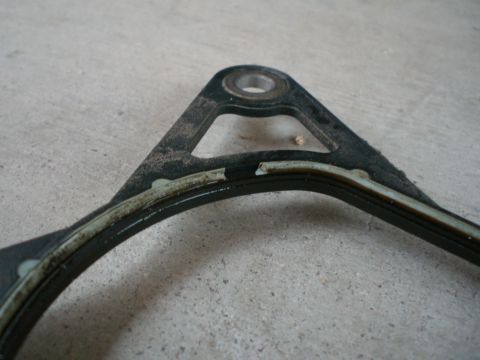 2000 Mercury Grand Marquis - Close-up of a damaged engine gasket, showing wear and tear on the sealing component.
