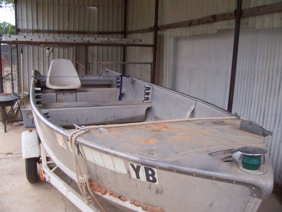 Aluminum boat on trailer with visible markings YB
