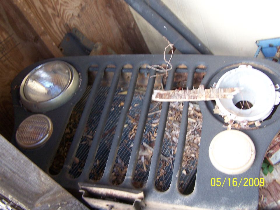 Jeep CJ grille with round headlights and vertical bars, showing debris inside