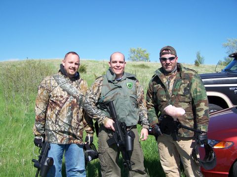 1986 Ford Bronco - Three men in camouflage gear stand outdoors holding paintball guns.