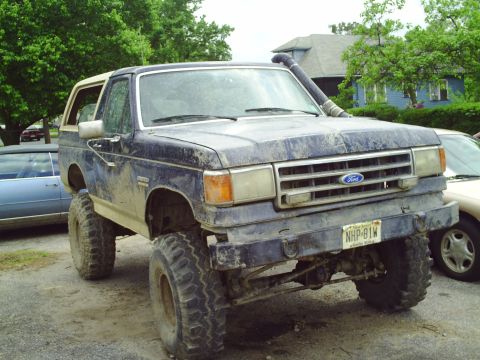 1990 Ford Bronco - Modified 1990 Ford Bronco features a snorkel and lift kit, parked outdoors.