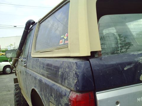 1990 Ford Bronco - This modified Ford Bronco features a snorkel and appears to be covered in mud, suggesting off-road use.
